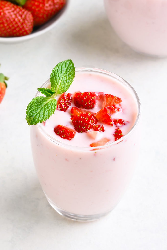 Strawberries, mint and Sahara Blueberry Kefir in a glass cup.